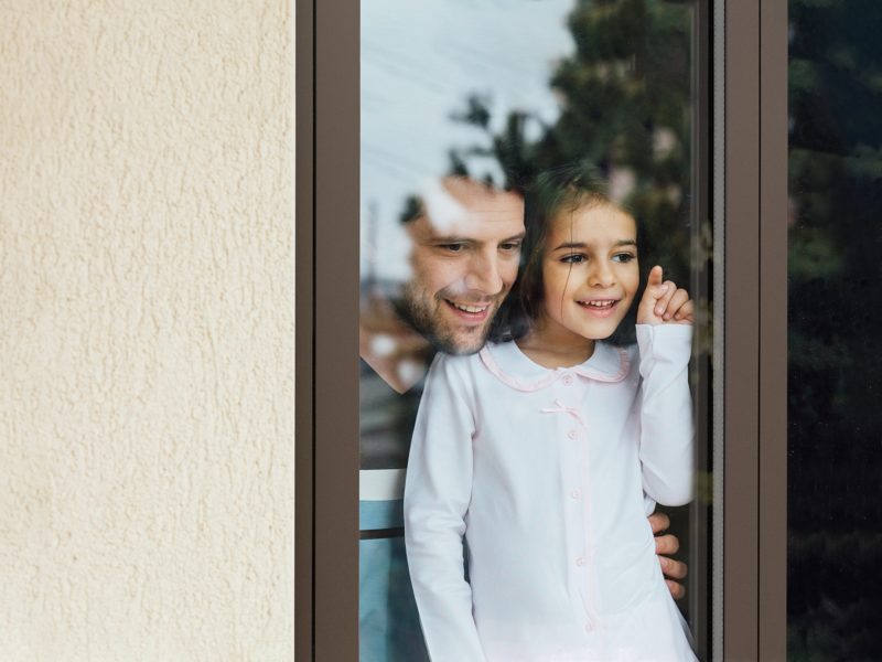 daughter and father looking through flush door
